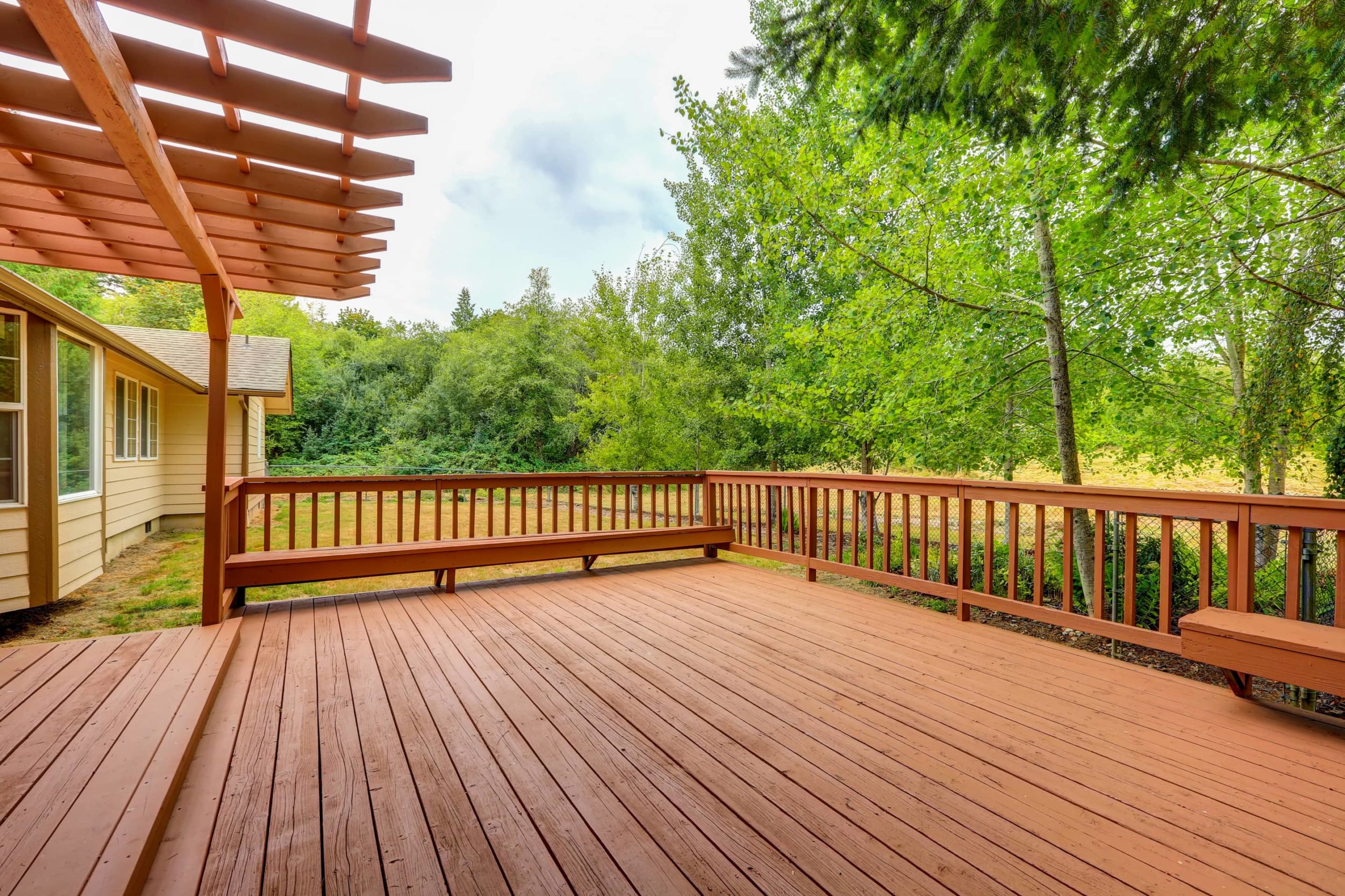 This image shows a beautifully crafted large wooden deck and pergola.